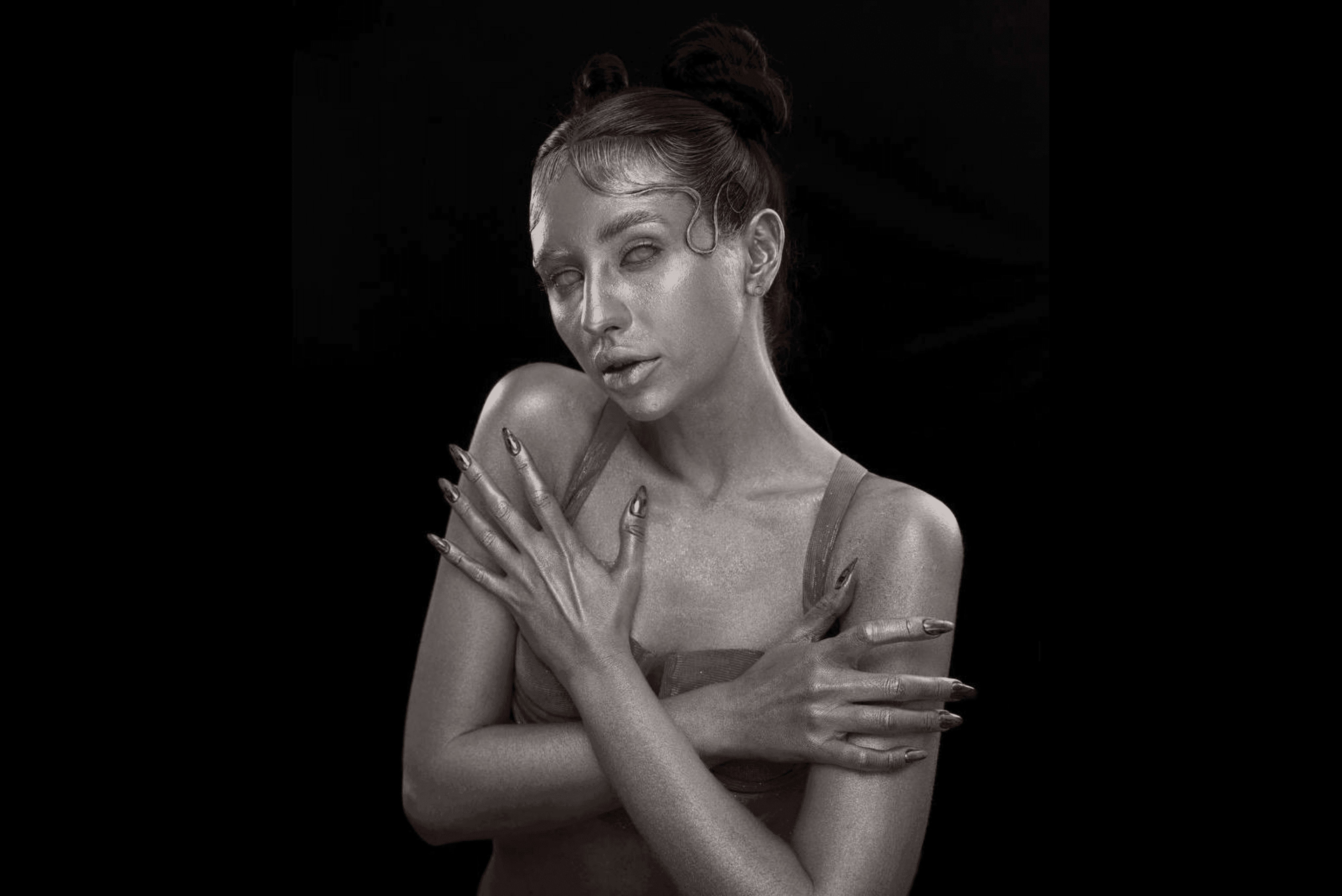 Black-and-white portrait of a woman posing with arms crossed over her shoulders, creating a dramatic, editorial skincare look.
