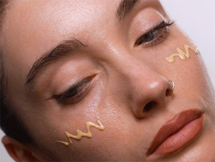 Woman with sunscreen dots applied across her cheeks and nose, ready to be blended in.