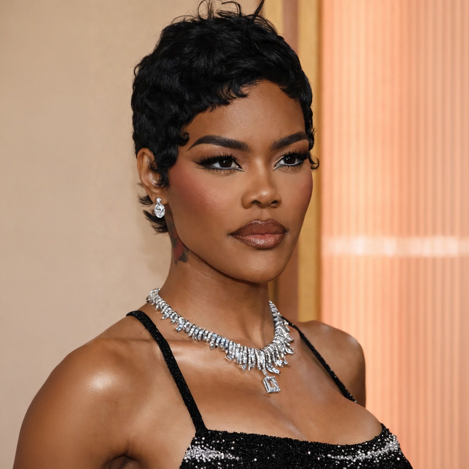 Teyana Taylor at the Oscars 2026 wearing a sharp double wing siren eye with glossy lips and luminous skin.