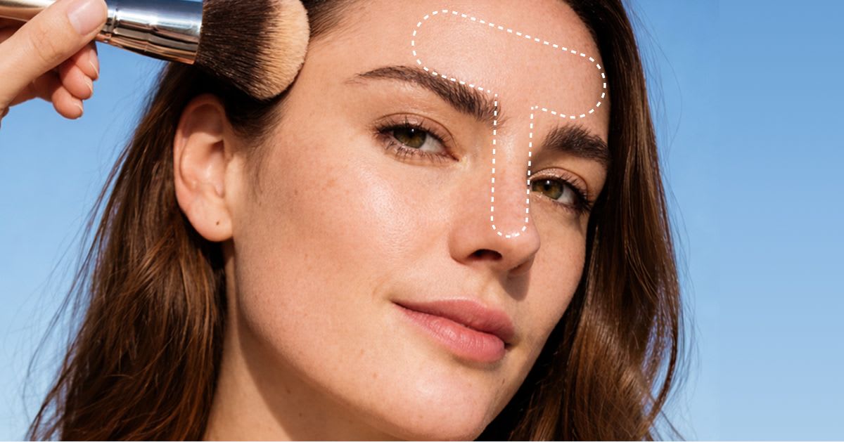 Close-up of a woman applying powder to her forehead with a makeup brush, with dotted guides highlighting the T-zone area for targeted application against a blue background.