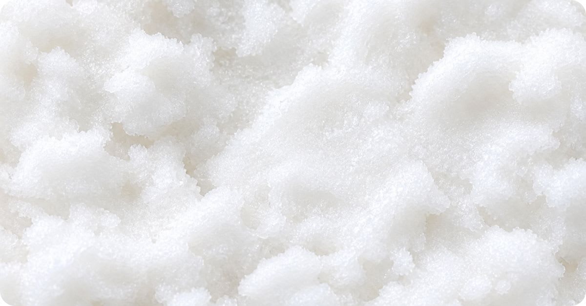 Close-up macro shot of fine white crystalline powder, representing the chemical appearance of hydroquinone, a controversial skin-lightening ingredient banned or restricted in many countries.