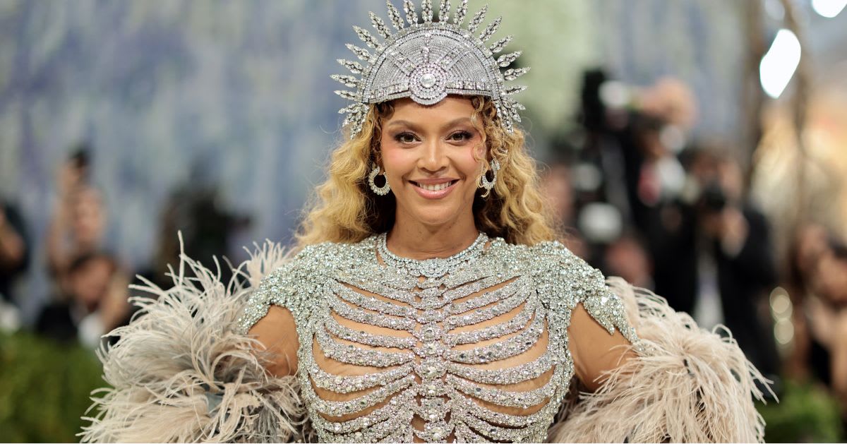 Beyoncé — Beyoncé on the Met Gala red carpet in a silver crystal-embellished gown with a ribcage-structured bodice, feathered skirt, and a jeweled crown headpiece