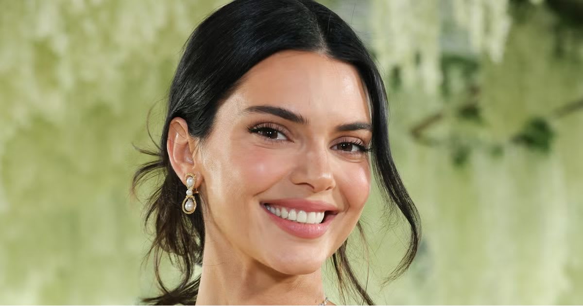 Kendall Jenner — Kendall Jenner at the Met Gala smiling, with dark hair pulled back and pearl drop earrings