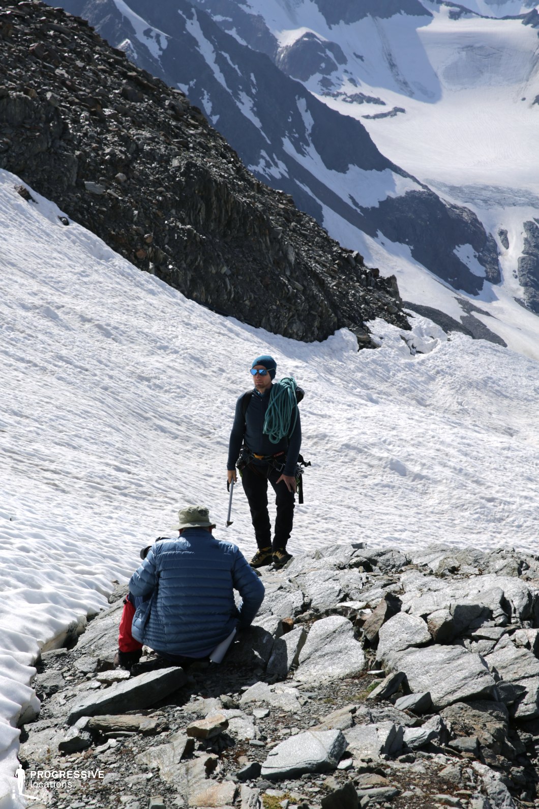This dramatic high-mountain location features a steep snowfield bordered by dark, jagged rock formations and expansive glacier backdrops. The raw, textured landscape provides a visually intense and physically demanding setting with a strong sense of elevation and remoteness. The surrounding ridges and icy terrain evoke tension and grandeur. This location is well-suited for survival thrillers, expedition dramas, or fantasy adventures—especially scenes depicting treacherous crossings, isolated challenges, or heroic ascents in an unforgiving alpine environment.
