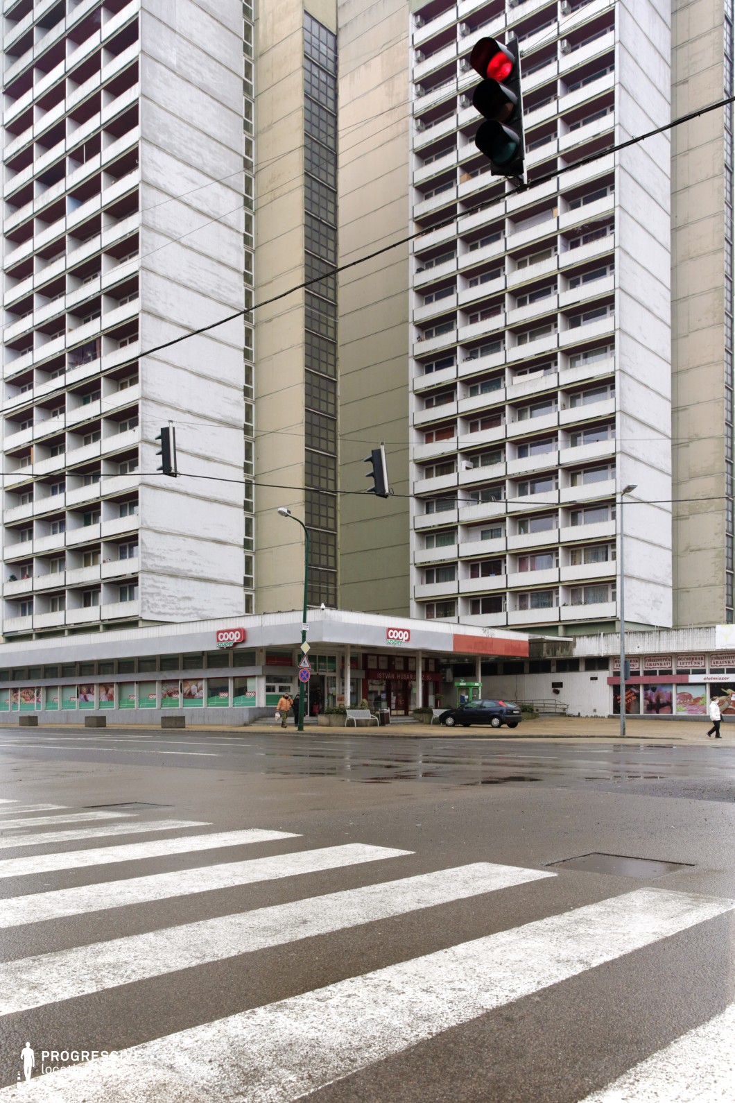 This image features Brutalist architecture with a large, imposing concrete residential building and a retail corner housing a 