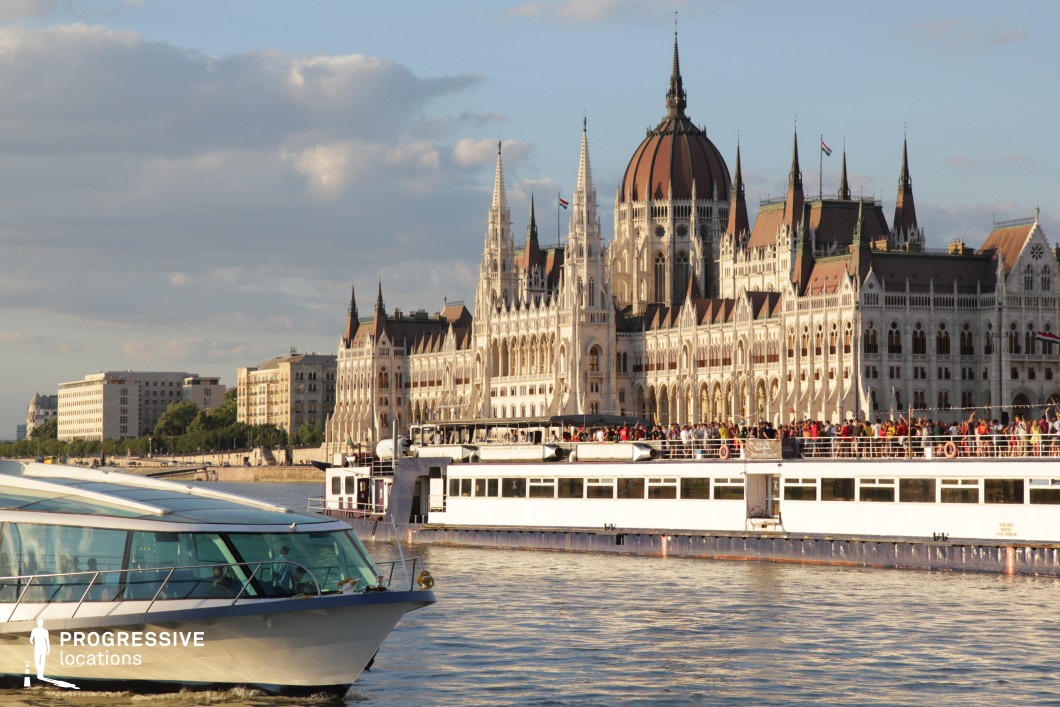 This is a scenic view of a grand gothic building, framed by the flowing Danube River. 