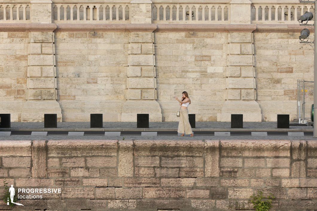 This is a grand architectural setting dominated by an expansive stone façade with intricate detailing and robust masonry.
