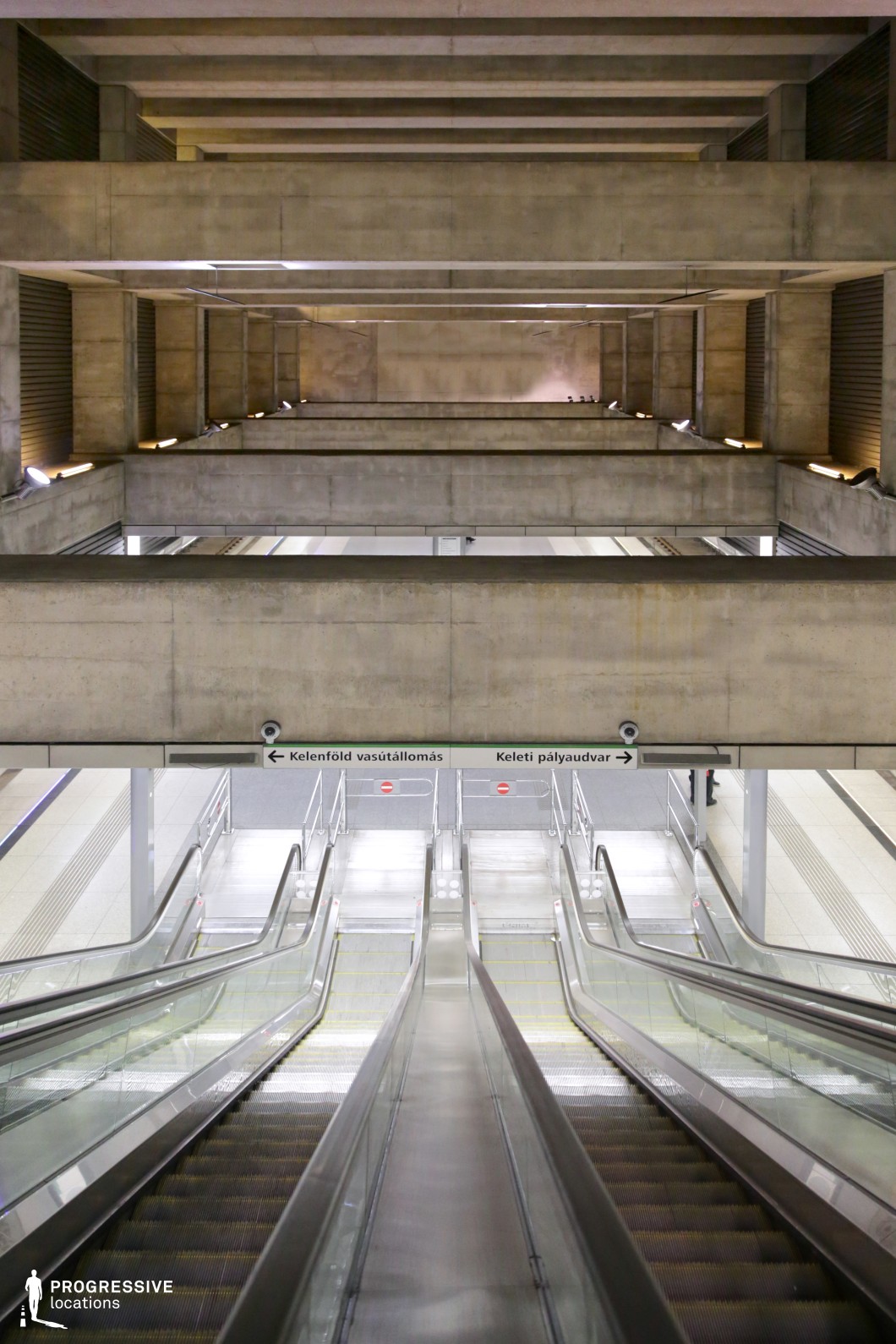 This expansive stairway showcases a brutalist architectural style, characterized by raw concrete surfaces and massive geometric overhangs. The descending escalators, lined with glass and steel railings, create a strong sense of depth and scale. Repetitive horizontal beams add a layered, tunnel-like effect, emphasizing the station’s vast, industrial atmosphere. Subtle lighting along the concrete surfaces enhances the textures, making this an ideal setting for cinematic scenes with a futuristic, dystopian, or high-concept aesthetic.