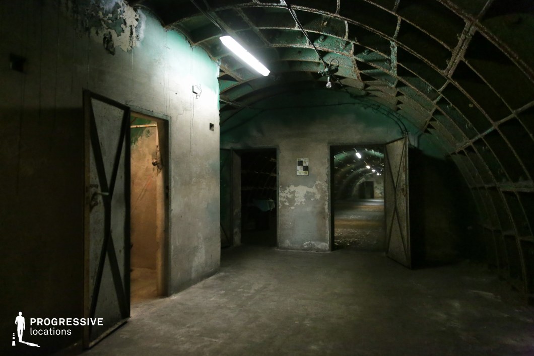 Concrete chamber with metal doors and arched tunnels, a film and photography location with raw industrial style.