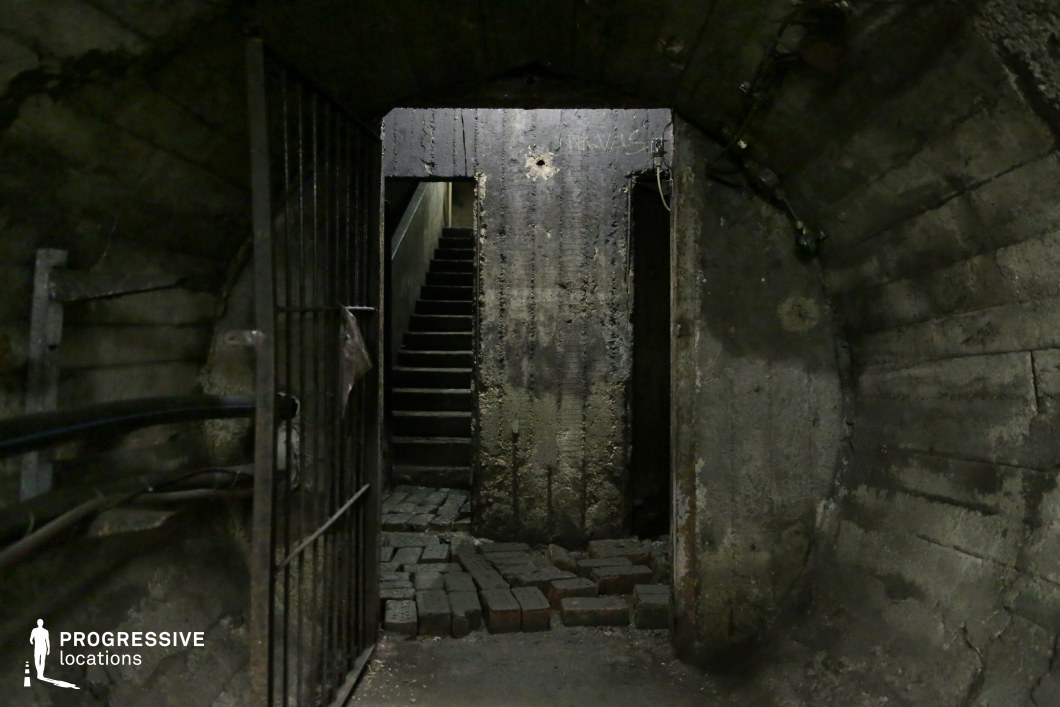 Concrete tunnel with stairway and metal gate, an underground film and photography location with authentic texture.