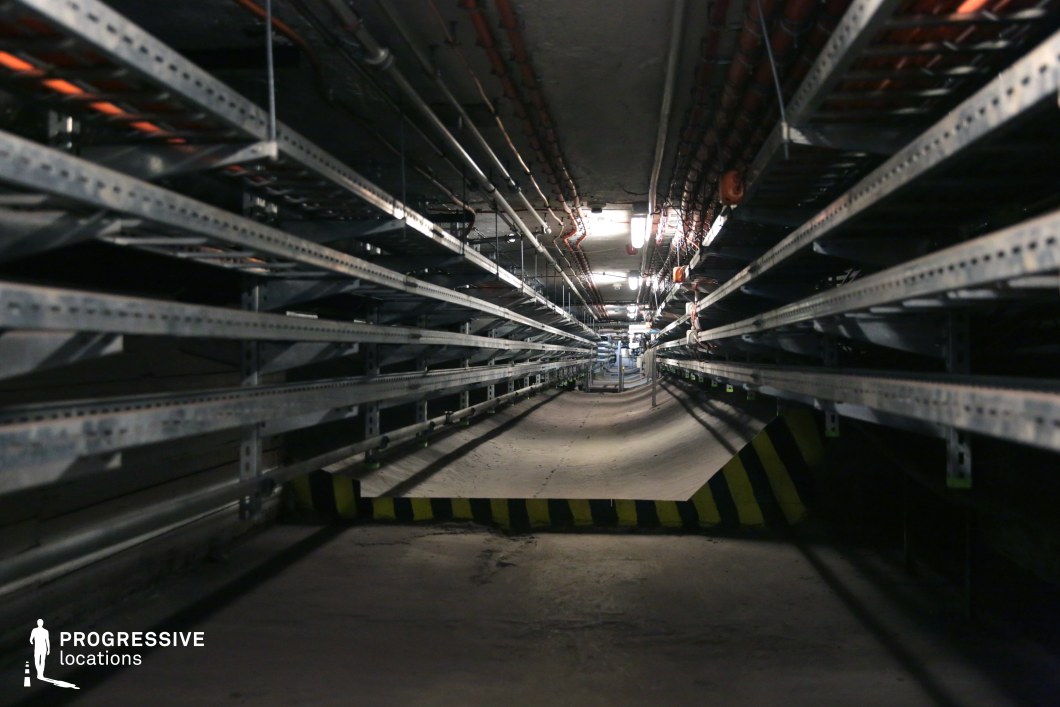 Underground tunnel with dense cable lines and lights, a film and photography location emphasizing industrial design.