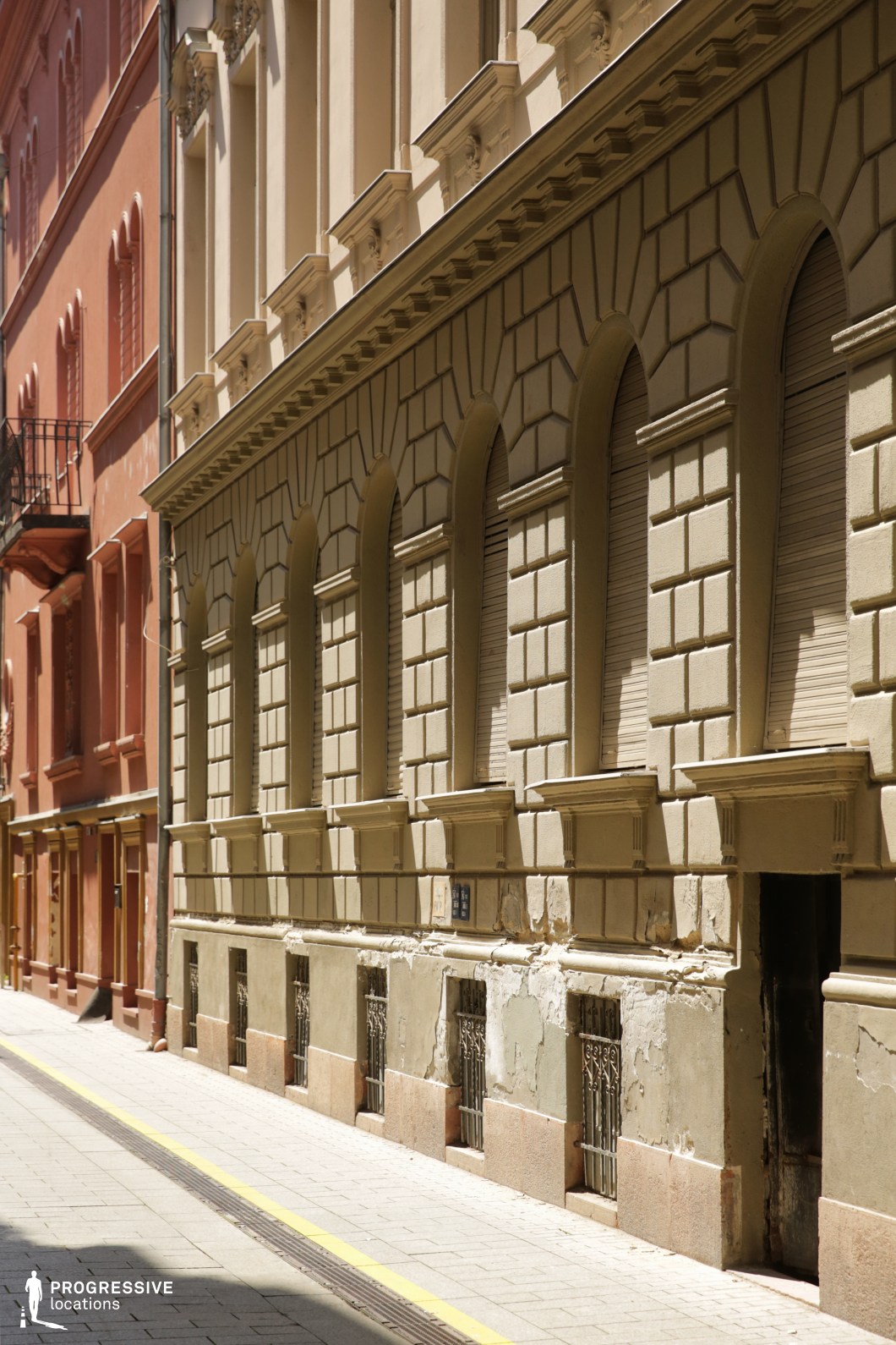 Repeating arched windows on classic facade, ideal location for photography and filming with strong symmetry and linear depth