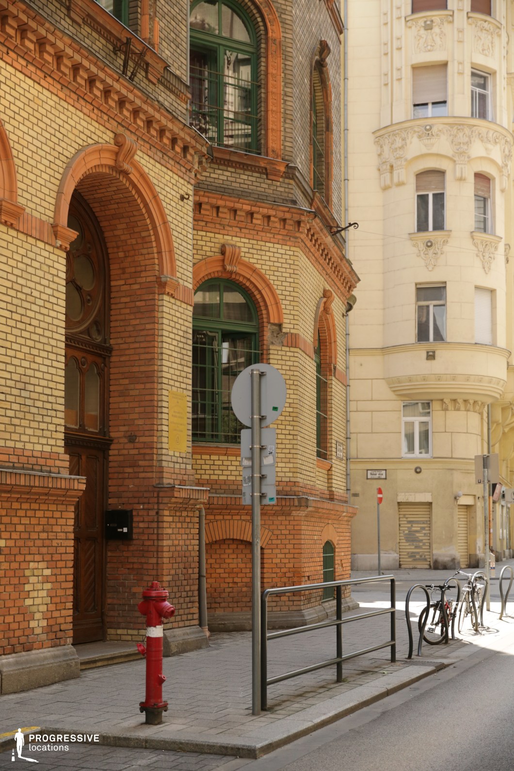 Brick facade with arched windows and detailed structure, film and photography location with rich texture and layered urban backdrop