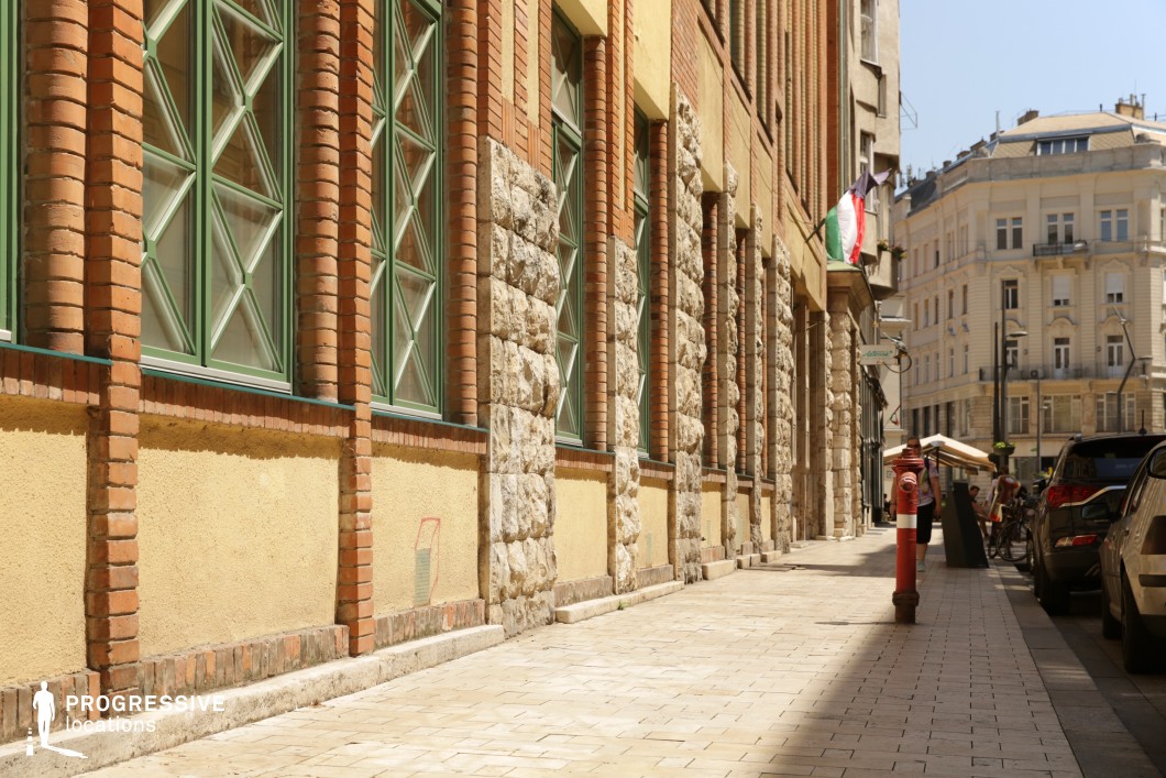 Brick and stone facade along sidewalk, photography and film location with strong textures and elongated perspective