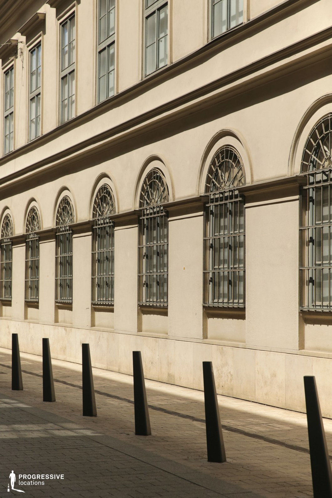 Row of arched windows with metal grilles, a photography and film location defined by repetition and linear architectural rhythm