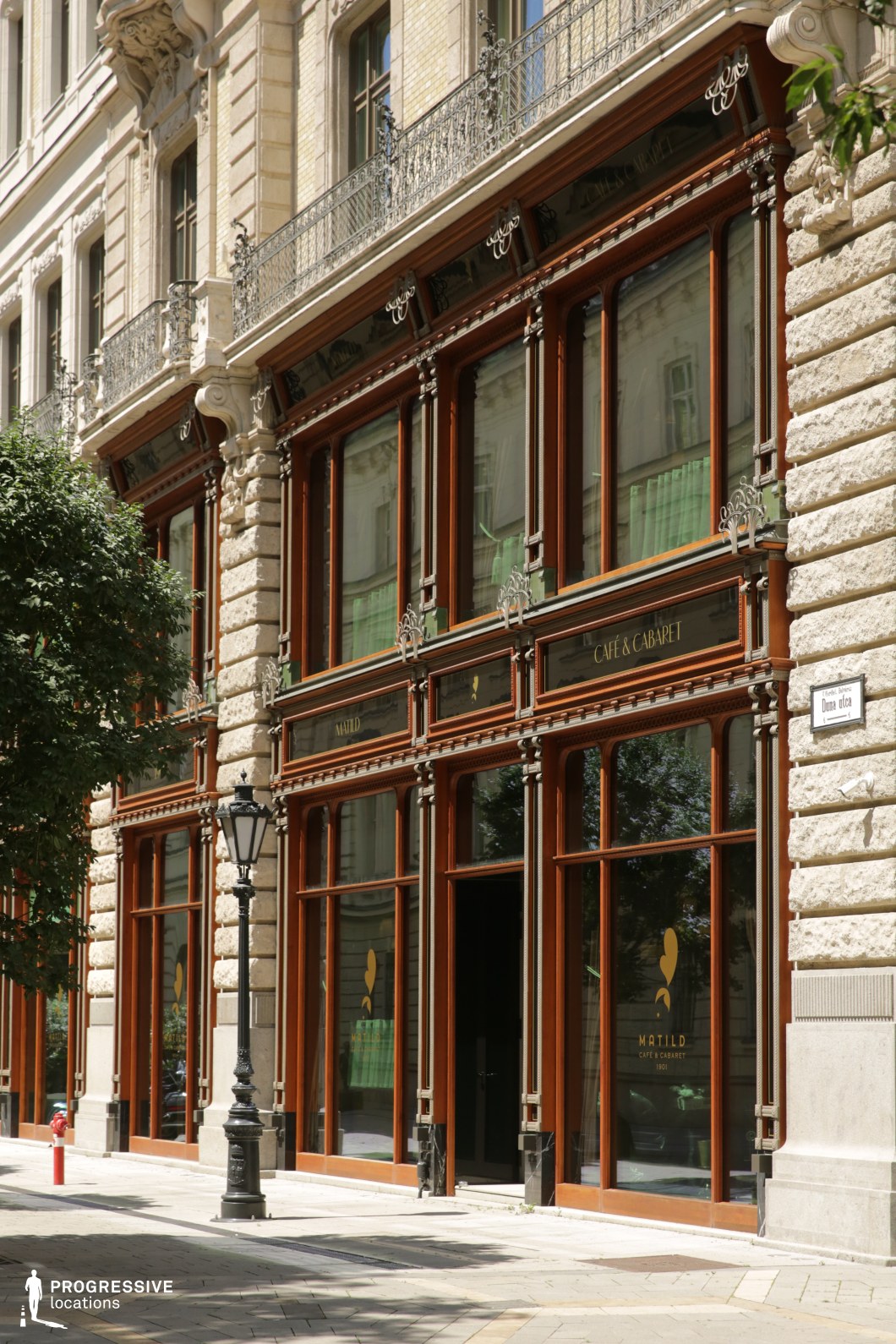 Ornate cafe facade with large windows, a film and photography location featuring detailed stonework and structured frontage