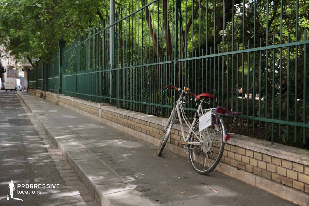 Sidewalk with metal fence and bicycle, photography and film location with linear composition and calm urban atmosphere