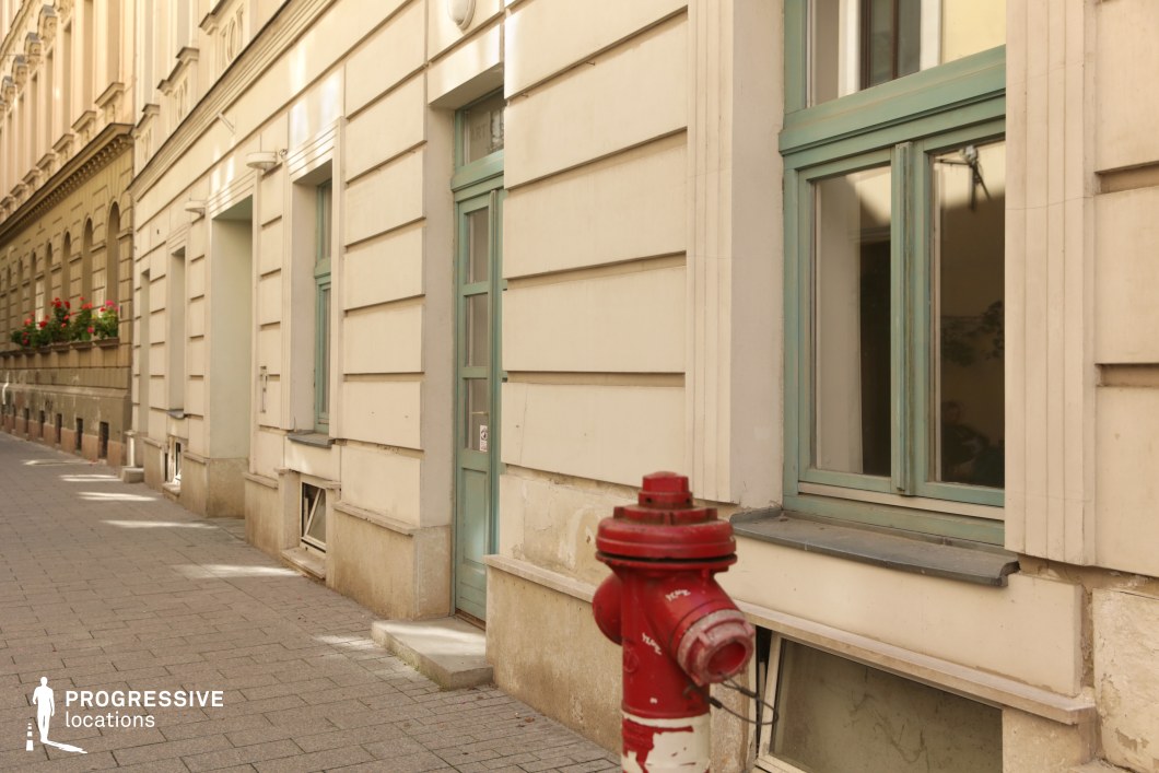 Sidewalk with hydrant and building facade, shooting location for film and photography projects with simple structure and clear foreground focus