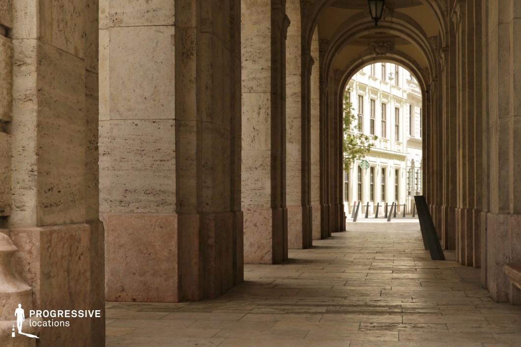 Stone corridor with repeating arches, a film and photography location featuring strong depth and enclosed architectural rhythm