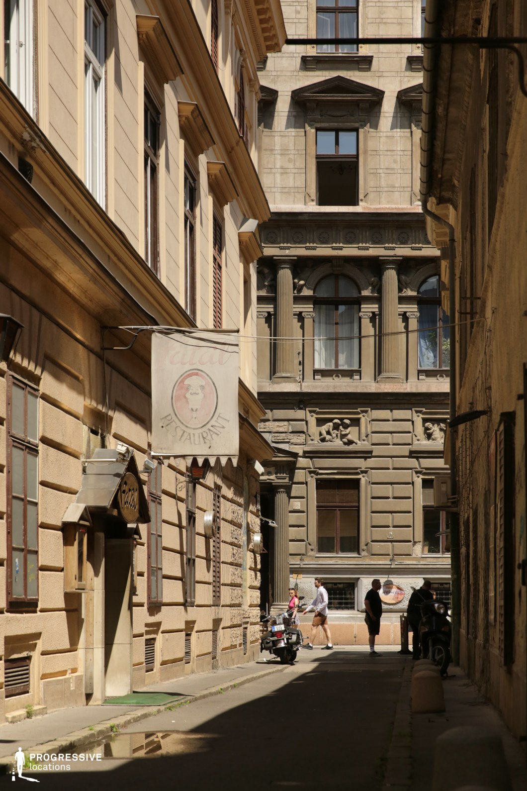 Tight alley with historic facades and narrow passage, photography and film location with strong depth and enclosed urban character