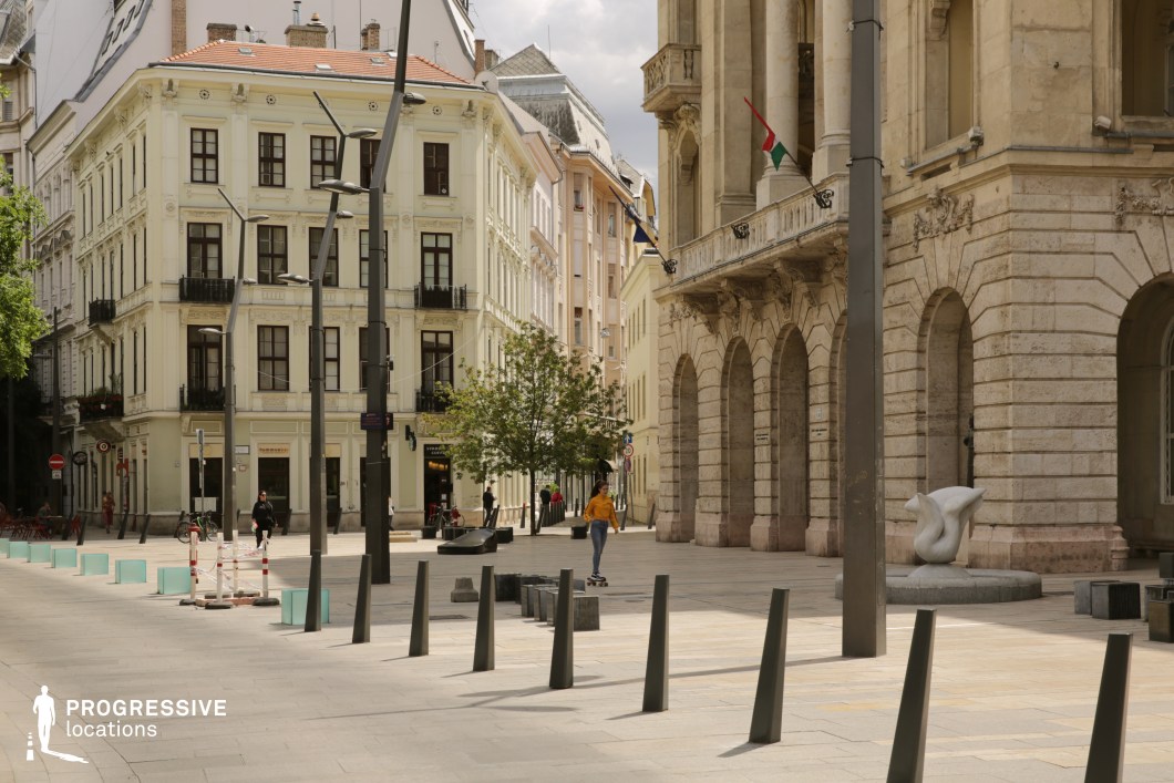 Open urban square with arcades and historic facades, a film and photography location with structured layout and clear spatial depth