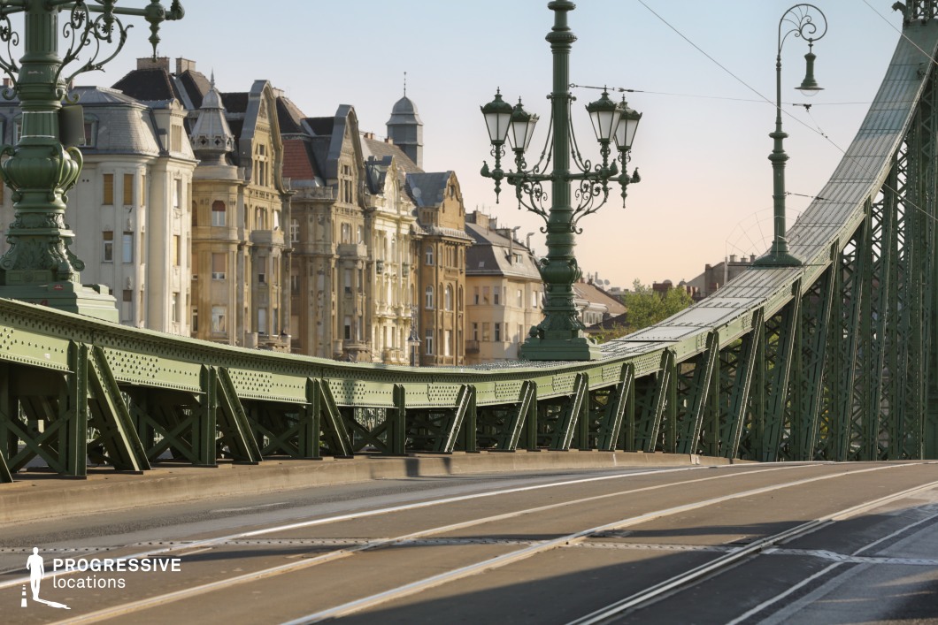 Ornate bridge lamps and green steel structure alongside historic buildings as a film and photography location