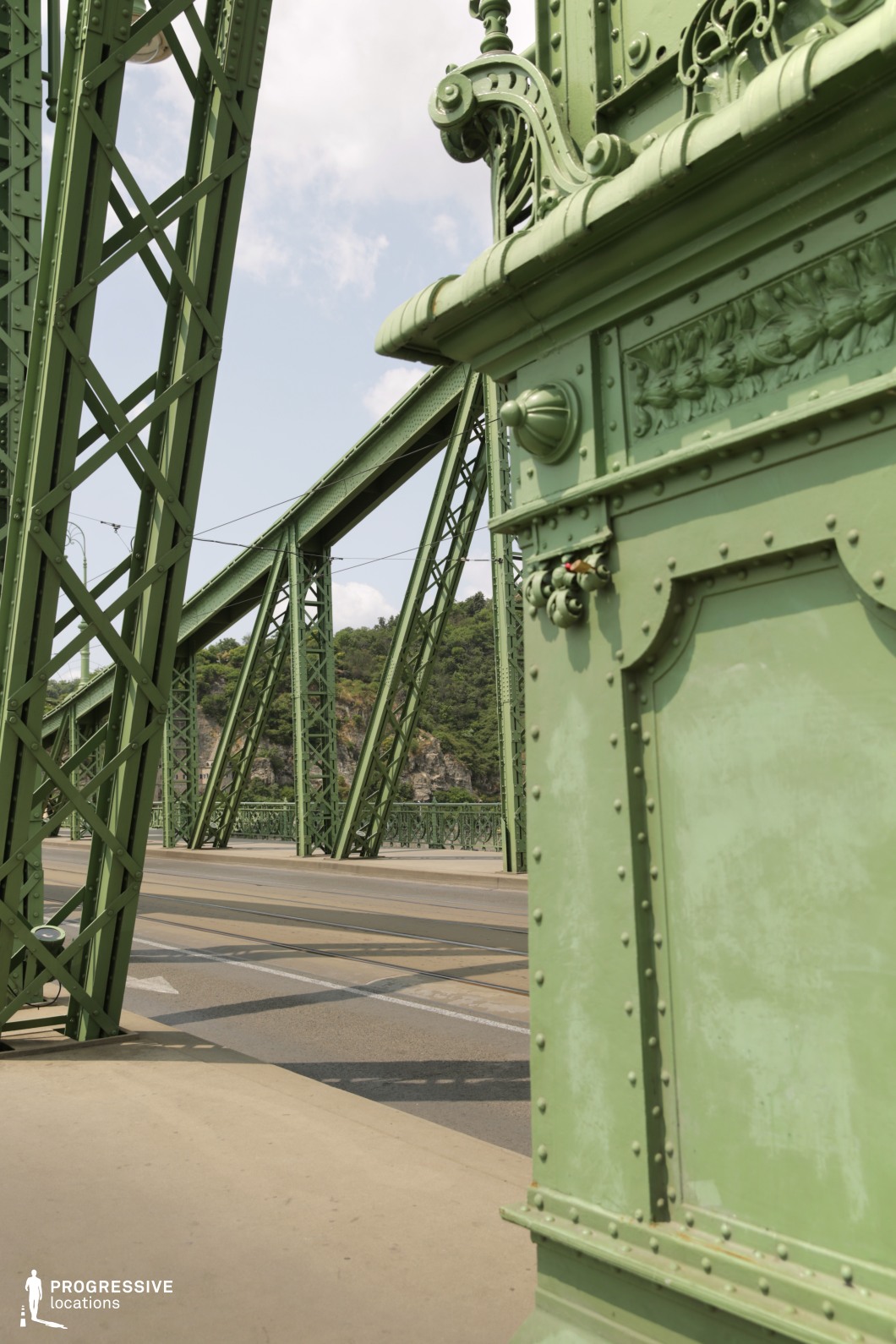 Green steel bridge column and truss structure forming a detailed film and photography location with strong geometry