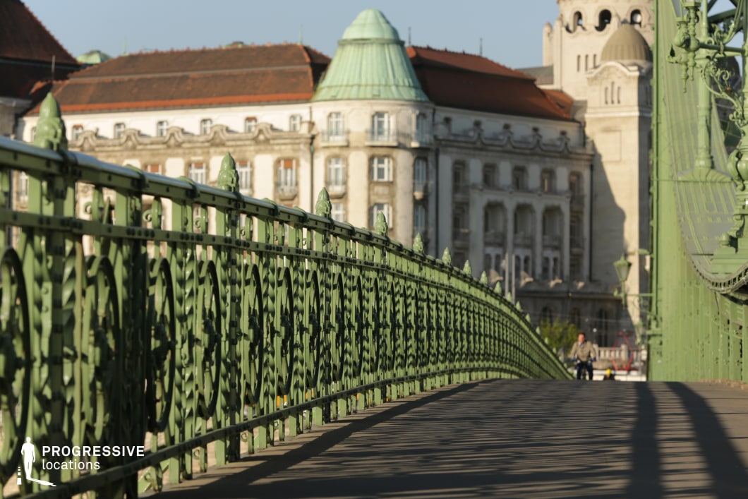 Ornate green iron railing along a bridge walkway creates a strong perspective as a film and photography location