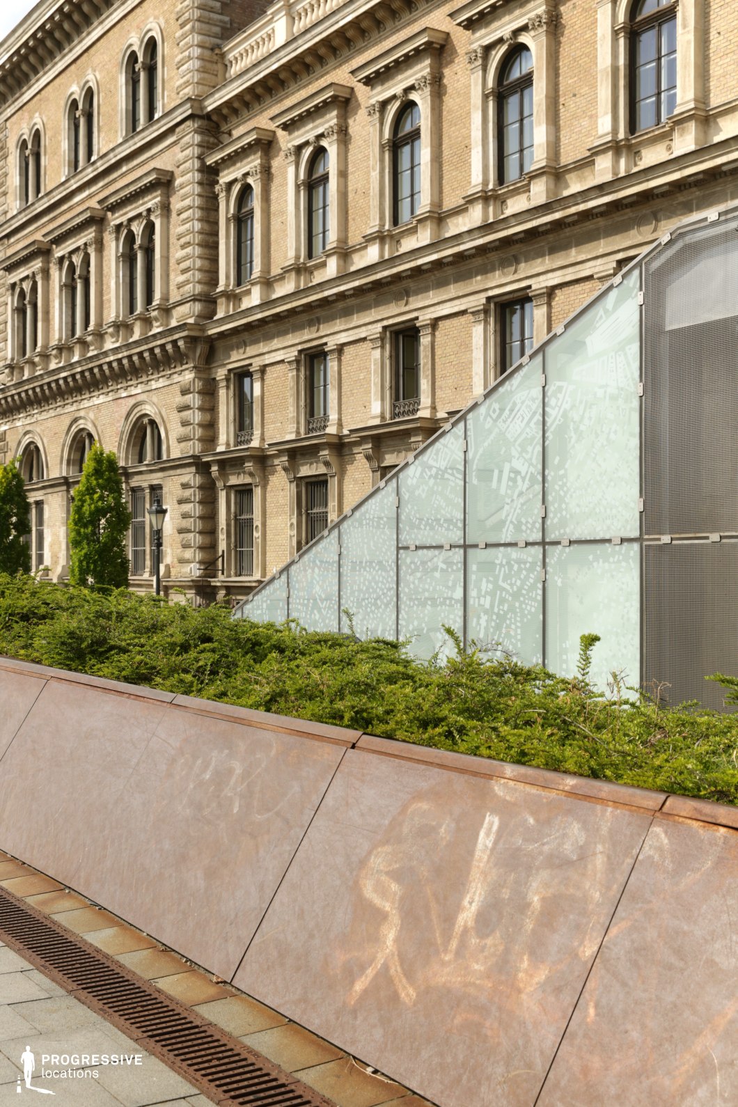 Historic facade beside a modern glass structure forming a photography and film location with architectural contrast