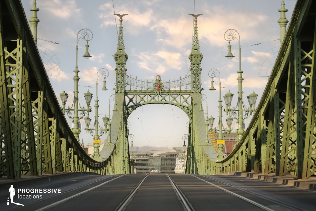 Symmetrical view of ornate green bridge arch with towers and tracks as a film and photography location