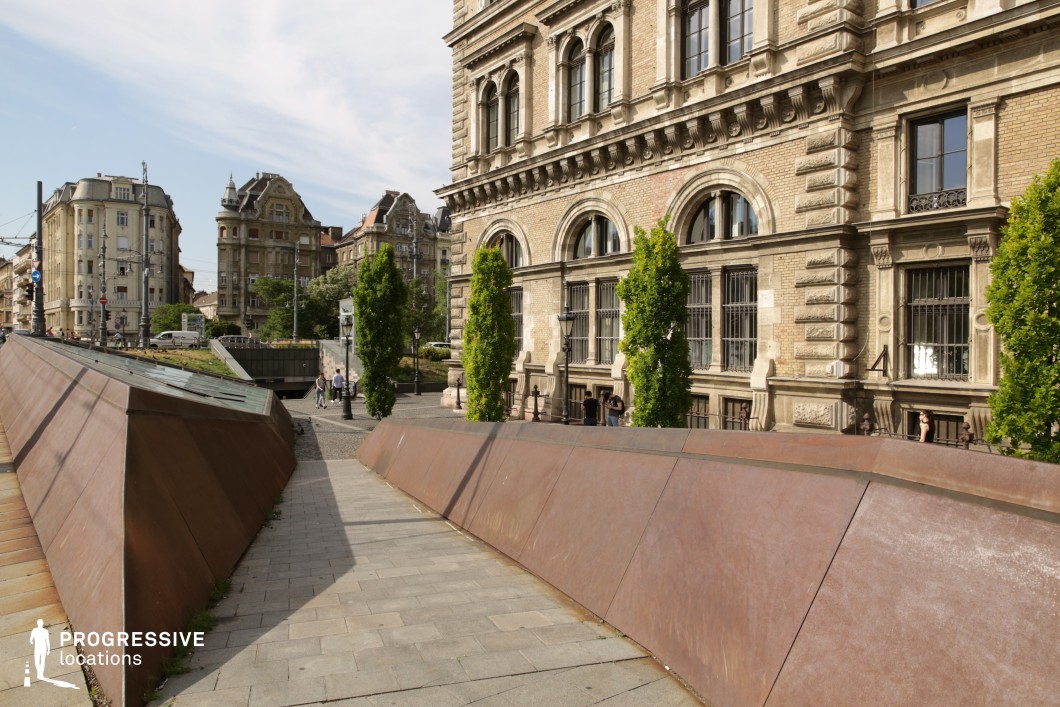 Modern urban walkway with angular metal structures near historic buildings as a photography and film location