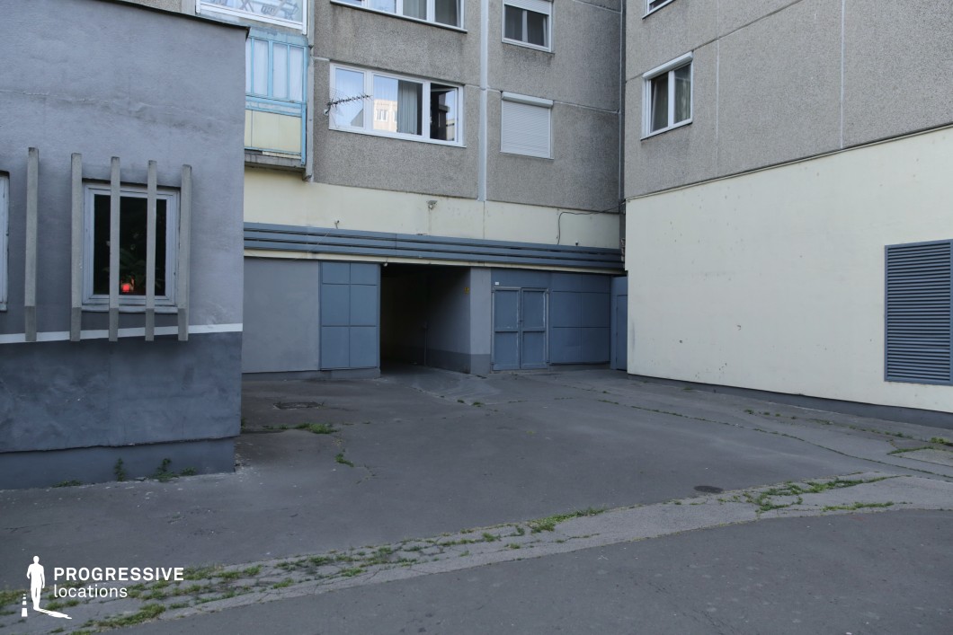 Enclosed service courtyard with utility doors and plain walls, film and photography location with minimal urban composition