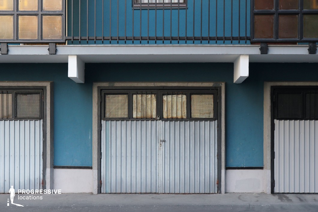 Row of metal garage doors under residential building, film and photography location with strong symmetry and repetition