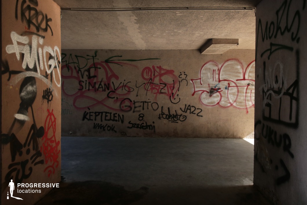 Graffiti-covered concrete underpass interior, shooting location for film and photography projects with enclosed industrial feel