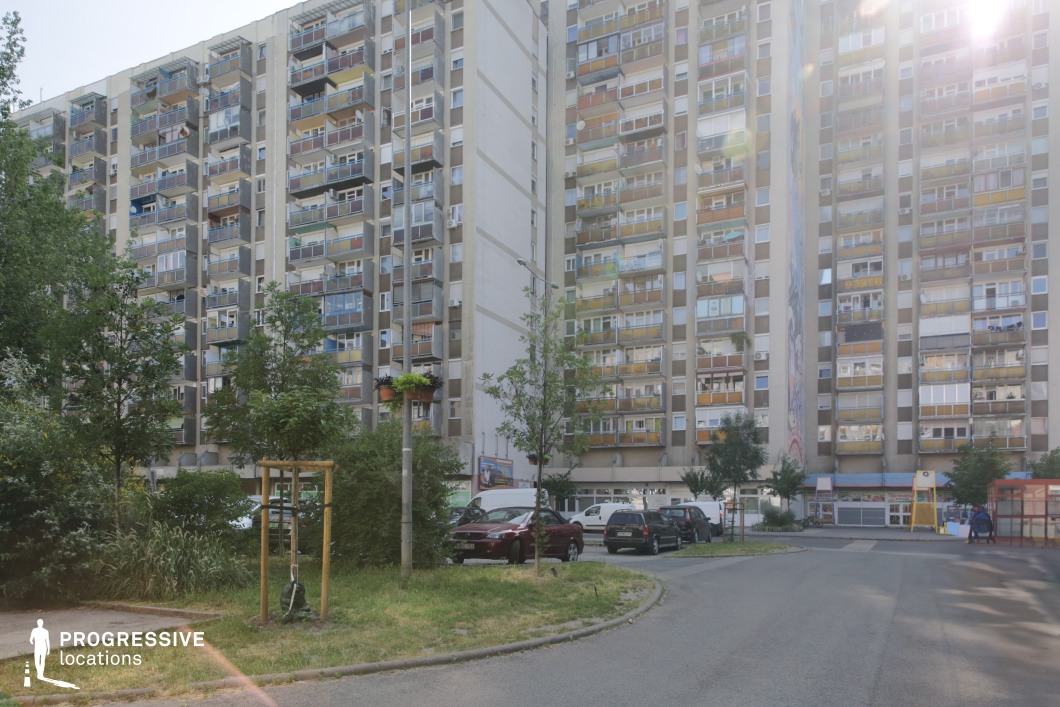 Open courtyard with high-rise apartment blocks and balcony grids, photography and film location with expansive urban depth