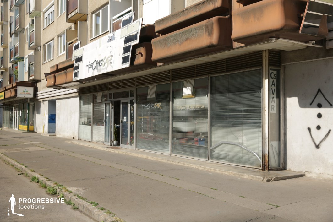 Row of storefront windows with canopy along sidewalk, film and photography location with strong linear perspective