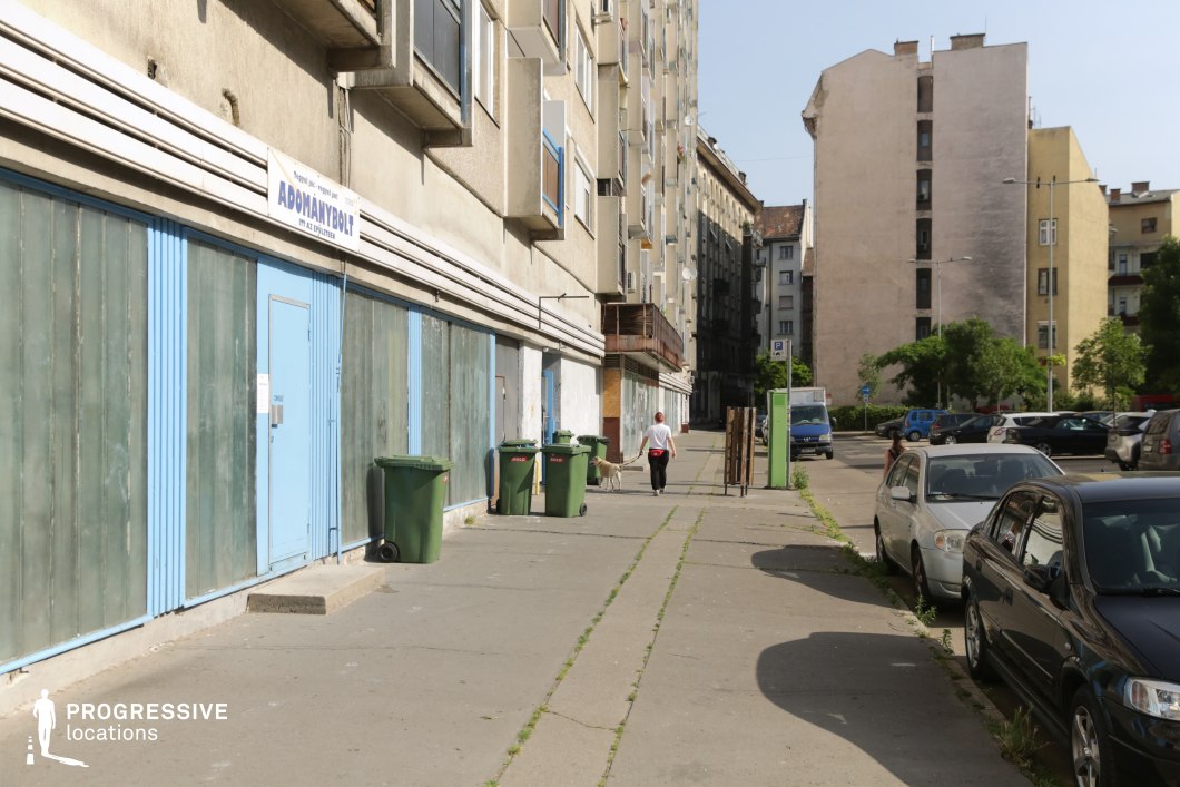 Long urban sidewalk beside apartment building, photography and film location with strong linear perspective and depth