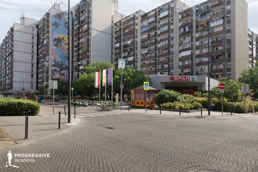 Open urban square with patterned pavement and apartment blocks, film and photography location with wide spatial layout