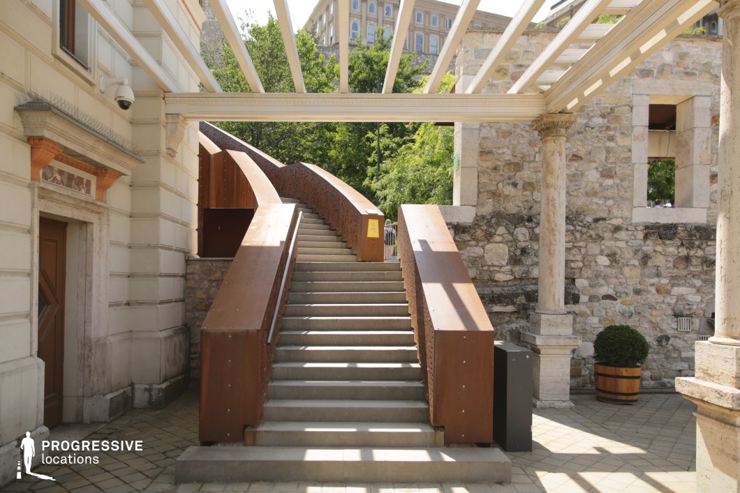 Modern metal staircase in historic courtyard used for film and photography location with contrasting materials and geometry
