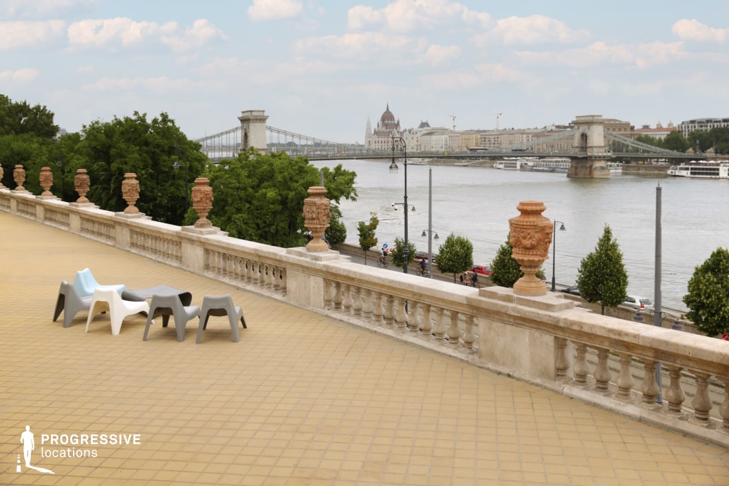 Open terrace with balustrade and seating used for film and photography location overlooking river and bridge