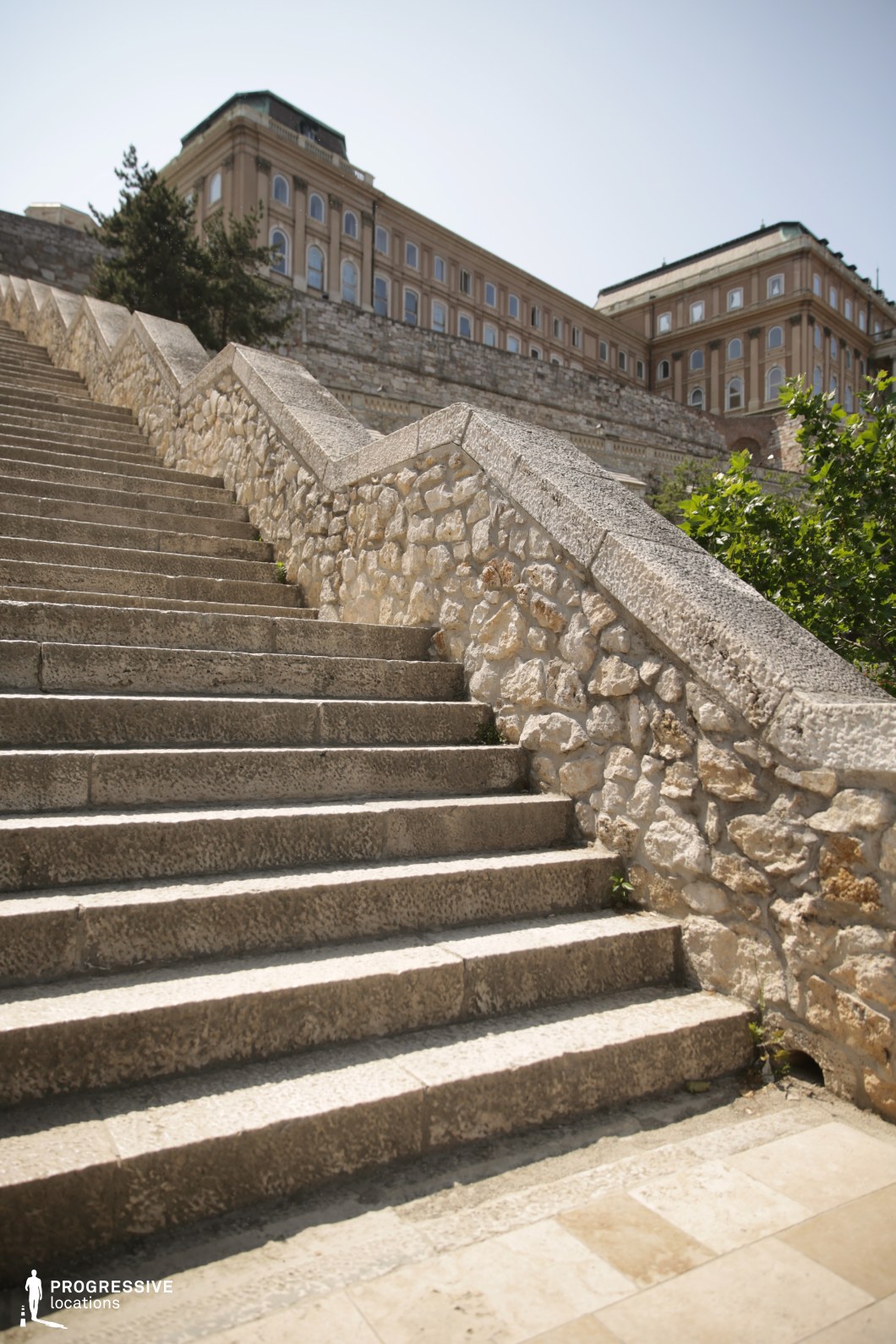 Wide stone staircase leading to historic building, a photography and film location with strong upward perspective and texture