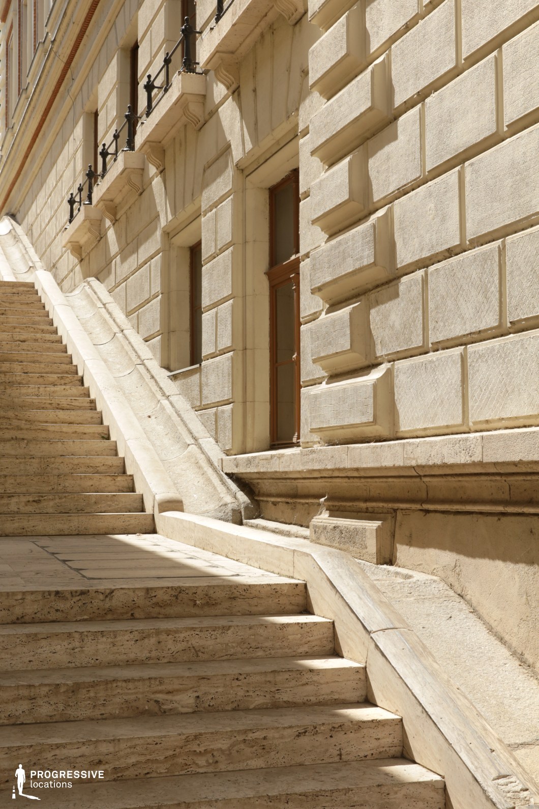 Stone staircase along facade offers a film and photography location with textured walls and diagonal composition