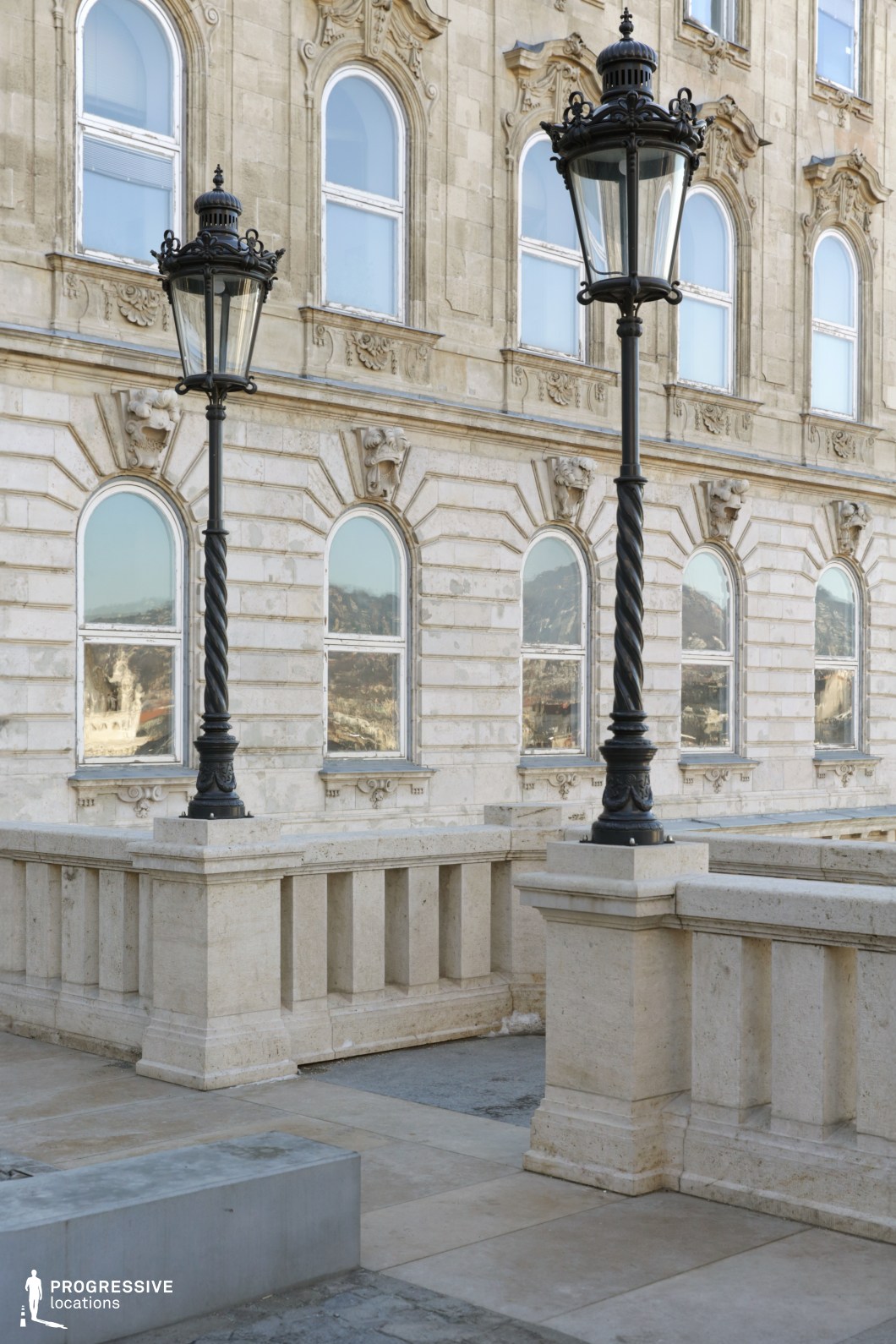 Ornate street lamps before historic facade, ideal film and photography location with detailed stone architecture and vertical elements