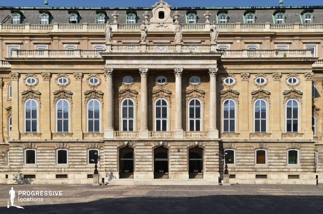 Symmetrical palace facade with columns and statues, photography and film location with grand scale and balanced composition