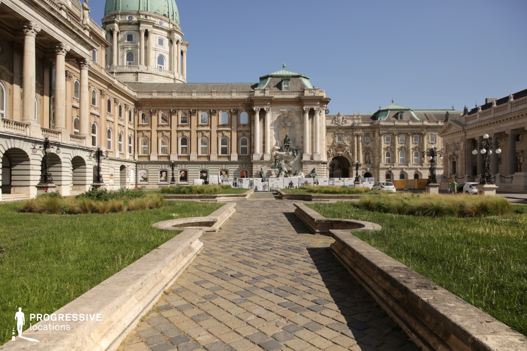 Symmetrical garden path leading to palace facade, a film and photography location with structured layout and classical architecture