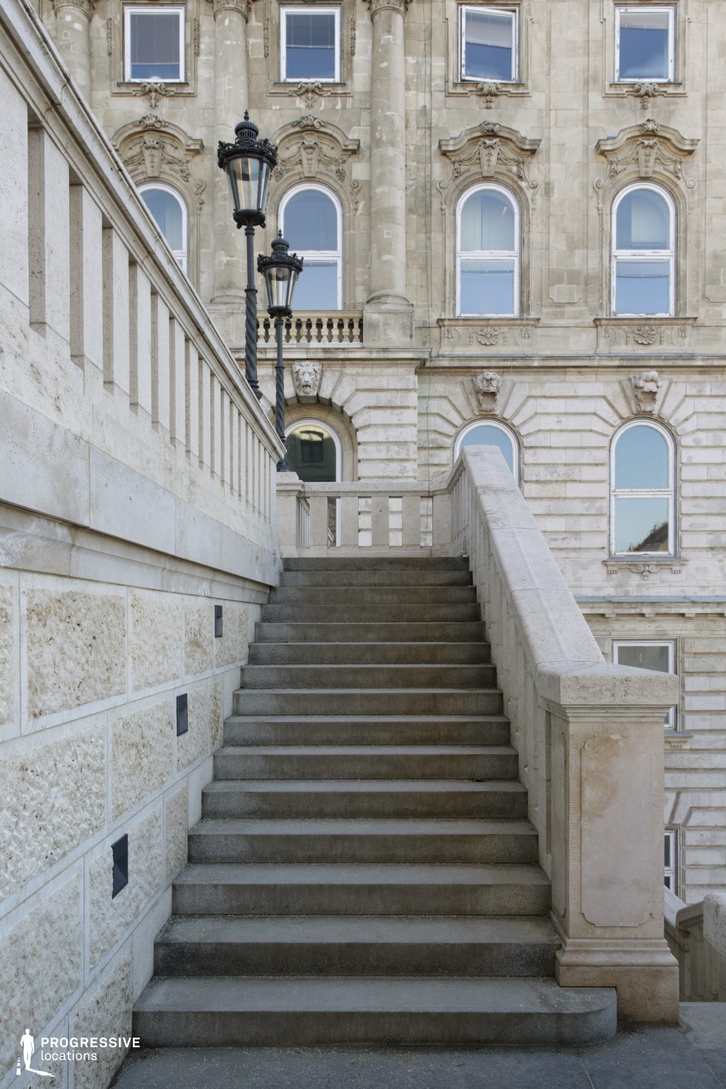 Stone staircase with ornate lamps and palace facade, a film and photography location with strong vertical lines and classical detail