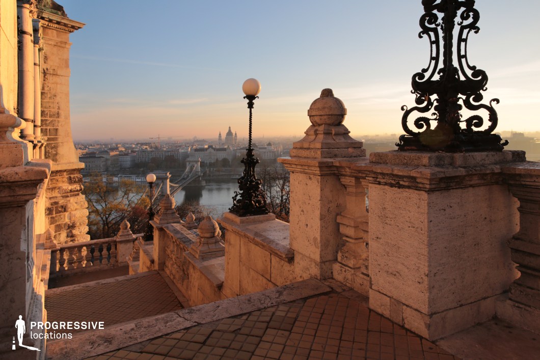 Historic stone staircase with ornate railings, ideal location for photography and filming overlooking a river and city skyline