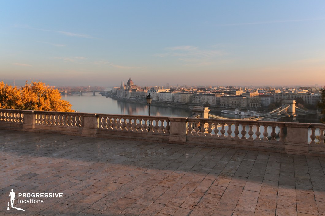 Open stone terrace overlooking river and city, photography and film location with wide space and clear architectural lines