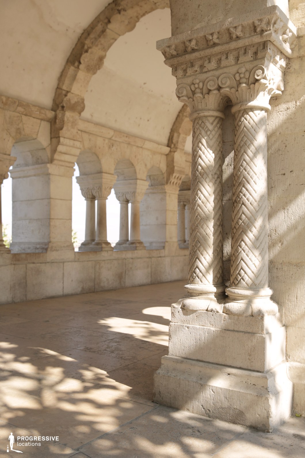Ornate carved stone columns in arcade, a film and photography location with repeating arches and detailed textures