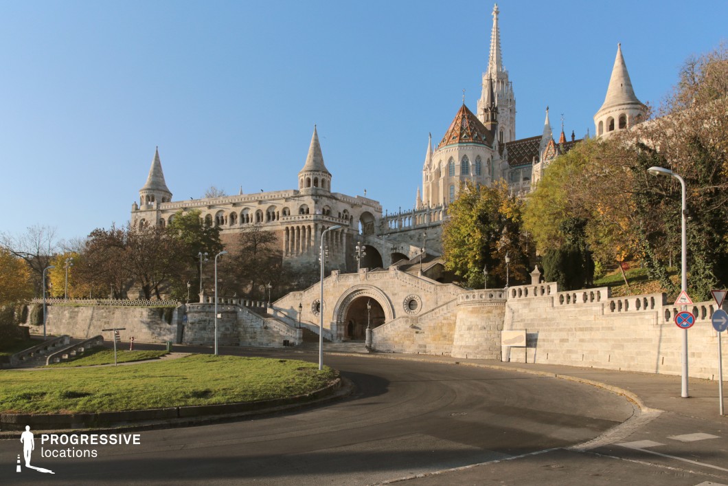Historic complex with towers and terraces above curved road, film and photography location with layered architecture and strong perspective